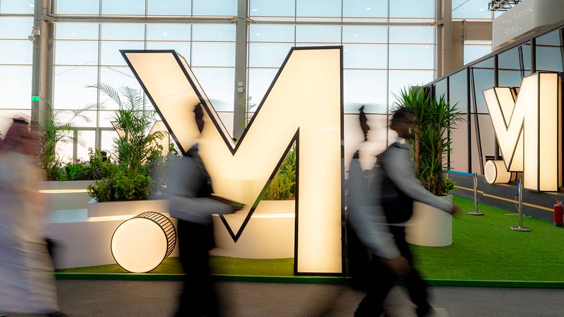 Money 20/20 image of people walking past sign